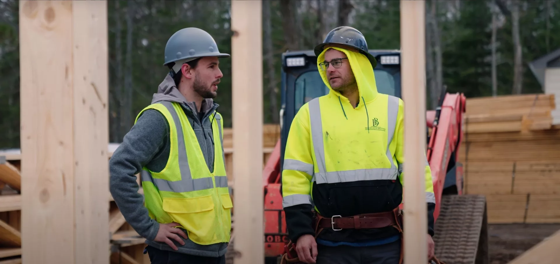 2 men in reflective clothing talking on a building site